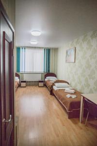 伊热夫斯克Hotel Mir的一间设有两张床和一张桌子的房间