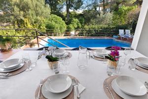 圣蓬萨Casa del Capitán的一张带盘子和玻璃杯的白色桌子和一个游泳池