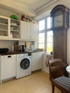 哥本哈根ApartmentInCopenhagen Apartment 1454的厨房配有洗衣机和时钟