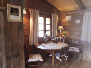 圣热尔韦莱班Charmant Mazot的木制客房配有桌椅和窗户。