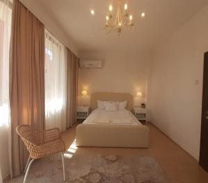 桑丹斯基Princess Apartment的卧室配有白色的床和吊灯。