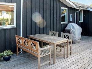 诺尔赫鲁普9 person holiday home in Hadsund的甲板上的木桌和椅子