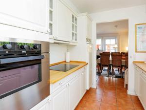 布拉万德4 person holiday home in Bl vand的厨房配有白色橱柜和炉灶烤箱。