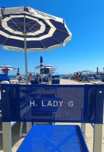 托尔托雷托Hotel Lady G的海滩上带遮阳伞的蓝色长椅