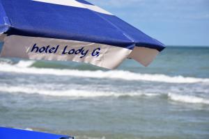 托尔托雷托Hotel Lady G的海滩上的蓝白遮阳伞