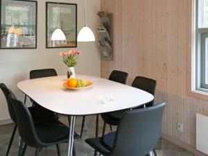 图鲁普斯特兰德6 person holiday home in Fjerritslev的一张带椅子的白色桌子和一碗水果