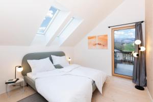 蒙德塞HIMMELBLAU - Design Apartment am Mondsee的一间卧室设有一张床和一个大窗户