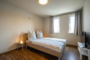 马尔肖Ferienhaus Hafenblick的一间卧室配有带枕头的床铺和电视。