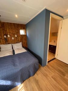 NoordlarenWaterjuffer的一间卧室设有一张床和蓝色的墙壁
