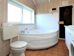 奥特尔恩多夫6 person holiday home in Otterndorf的带浴缸、卫生间和窗户的浴室