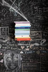 布鲁塞尔B'Kanal的一堆书放在墙上,上面有粉笔文字