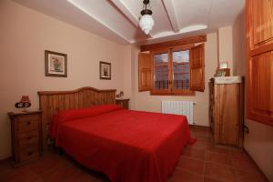 卡瓦内斯罗莎乡村民宿的一间卧室设有红色的床和窗户。