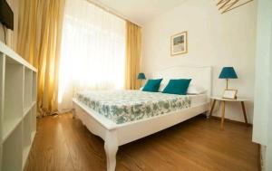 地拉那Hotel Artist的一间卧室配有一张带蓝色枕头的床和一扇窗户。
