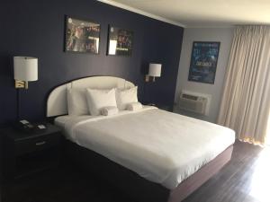 杜威海滩Hotel Dewey的卧室配有一张带白色床单和枕头的大床。