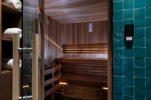 巴黎维多利亚广场酒店的一间设有木墙和蓝色瓷砖墙的桑拿浴室
