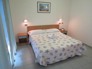 里米尼双子酒店的一间卧室配有一张床和两个床头柜