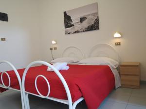 里米尼双子酒店的一间卧室配有一张带红色毯子的床