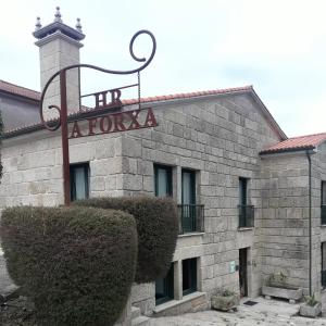 CarballeiraHotel A Forxa Cafetería Restaurante的建筑的侧面有标志