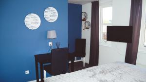 威廉斯塔德Hotel Willemstad的一间卧室配有书桌和蓝色的墙壁