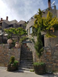 TzermiádonΑργουλιάς的一座石头建筑,前面有楼梯和树木