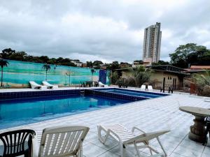 伊瓜苏Hotel Natureza Foz的一座带桌椅的游泳池以及一座建筑