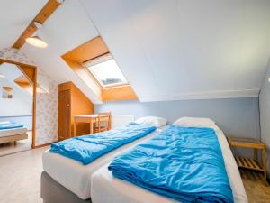 UlestratenSerene Holiday Home in Ulestraten near Private Forest的一间卧室配有两张蓝色床单