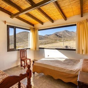 卡奇Cabaña Abra Del Monte的一间卧室设有一张床和一个大窗户