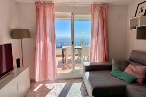 库姆布勒德尔索尔Fantástico apartamento con vistas panorámicas al mar的带沙发和大窗户的客厅