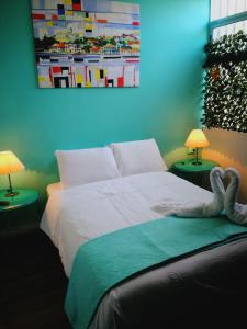 圣何塞NATIVUS Art-Hostel的一间卧室配有一张带两盏灯和一张照片的床。
