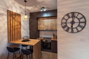 波德戈里察Modern, Bright and Cozy Apartment的厨房配有时钟和桌椅