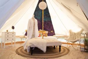 沃特金斯格伦Naturluxe & Stars的一间卧室,配有带一张床和一张桌子的帐篷
