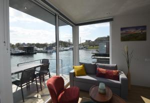 马斯特里赫特Floating vacationhome Sylt的带沙发的客厅,享有水景