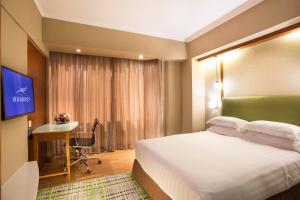 香港粤海华美湾际酒店的酒店客房配有一张床、一张书桌和一台电视。