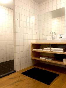德里默伦Bed and Breakfast De Biesbosch - in 't Riet的一间带水槽和镜子的浴室