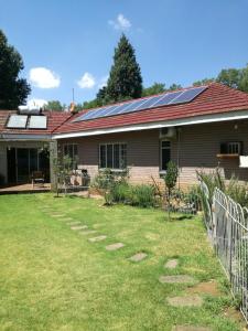 范德拜尔帕克Trinity Cottage的屋顶上设有太阳能电池板的房子