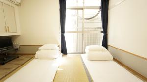 东京池袋宾馆的客厅配有2个白色枕头和窗户