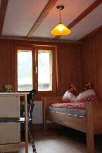 坎德施泰格Harri's BnB in Kandersteg, Ferienwohnung的卧室配有床、桌子和窗户。