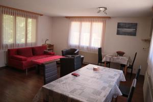 坎德施泰格Harri's BnB in Kandersteg, Ferienwohnung的客厅配有红色的沙发和桌子