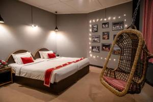 西隆Woodstock Resort的一间卧室配有一张床和一张挂椅