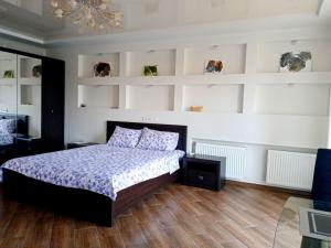 切尔卡瑟1-room Studio center的一间卧室设有床铺、白色墙壁和木地板