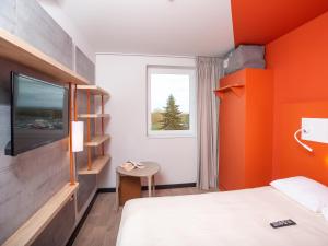 沙托贝尔纳尔ibis Budget Cognac的客房设有床、电视和窗户。