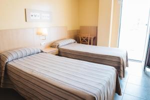 贝尼多姆特拉尔达旅行者公寓式酒店的酒店客房设有两张床和窗户。