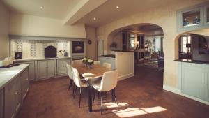 沙布利La Villa Celestine的厨房配有木桌和白色椅子