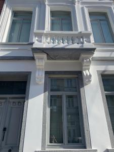 布鲁塞尔Brussels Guest House的白色的建筑,设有窗户和阳台