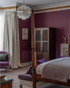 阿利士太纳雷酒店的一间卧室设有紫色的墙壁、一张床和一个吊灯。