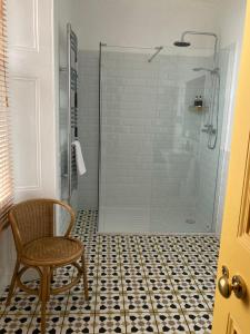 阿利士太纳雷酒店的浴室设有玻璃淋浴、椅子和卫生间