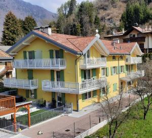 皮耶韦迪莱德罗La mansarda di Rossella的黄色房子,在街上设有白色阳台