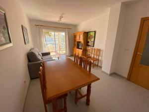 阿尔考斯布里Apartamentos Serenamar Altamar的用餐室以及带桌椅的起居室。