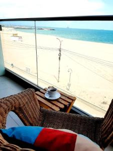 艾福雷诺德Vila Ryanna Beach pe plaja Belona的配有桌子并享有海滩景色的客房