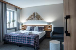 卡尔帕奇诺瓦-滑雪SPA酒店的配有一张床和一把椅子的酒店客房